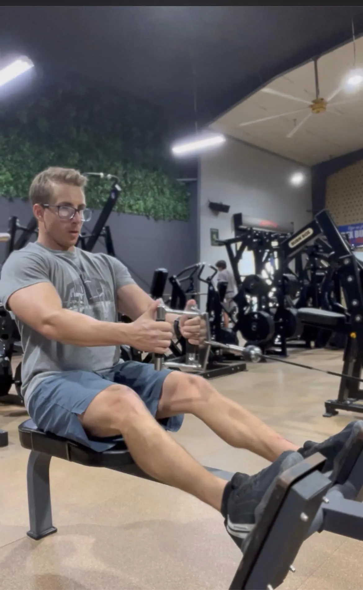 A personal trainer doing a seated row exercise.